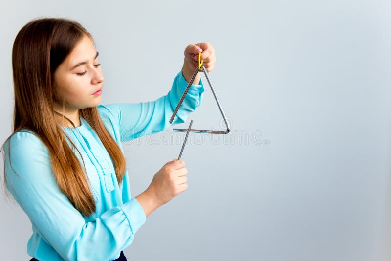 portrait-young-girl-playing-triangle-plays-110390570.jpg