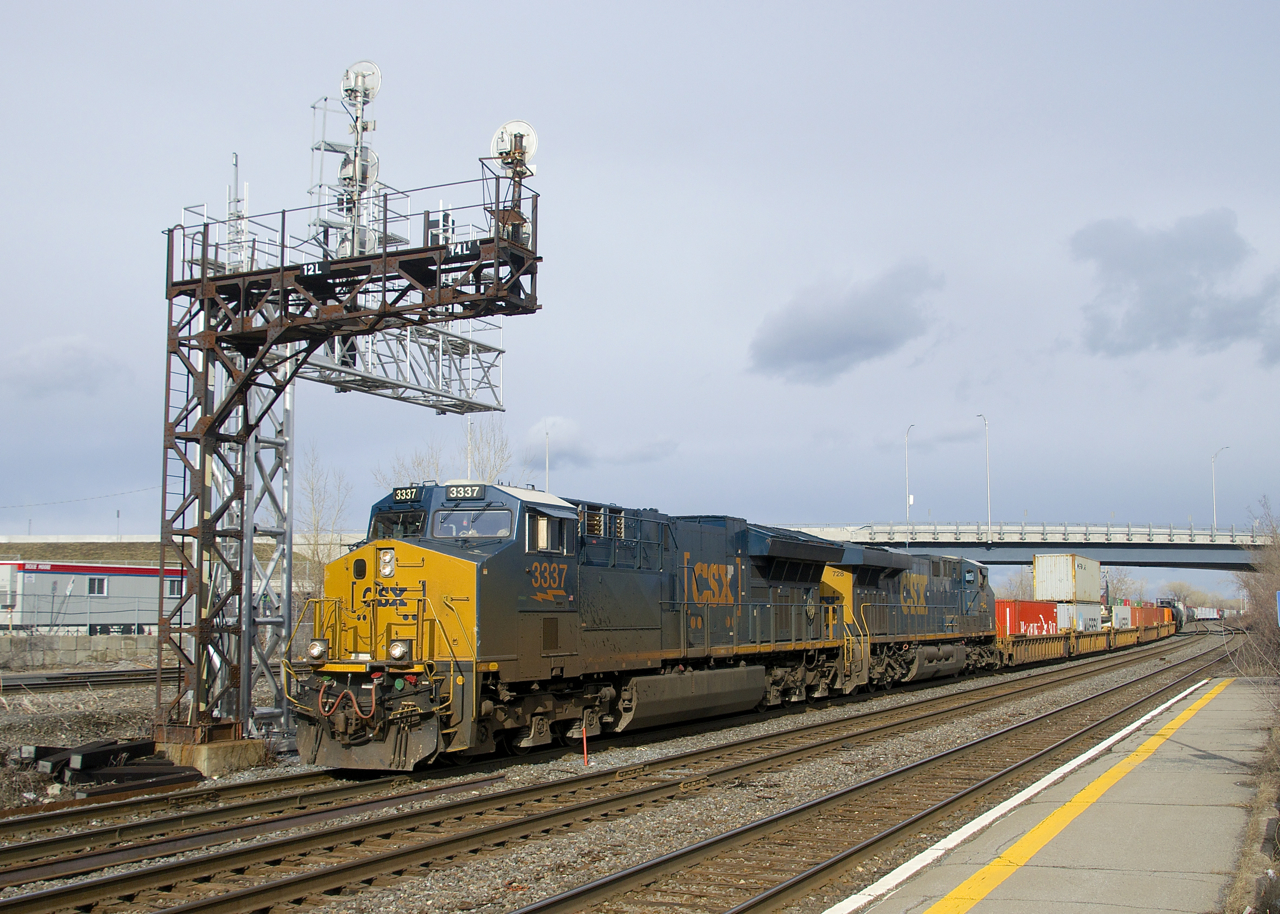 CN 327 has CSXT 3337 and CSXT 728 for power as it heads through Dorval with 6 intermodal cars up front, followed by mixed freight.